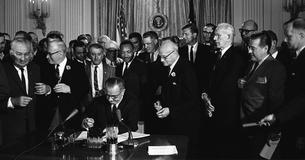 President Johnson signs the Civil Rights Act into law