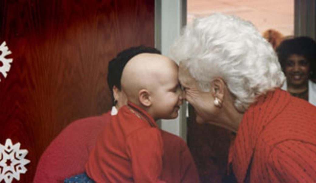 Barbara Bush interacting with a child undergoing cancer treatment