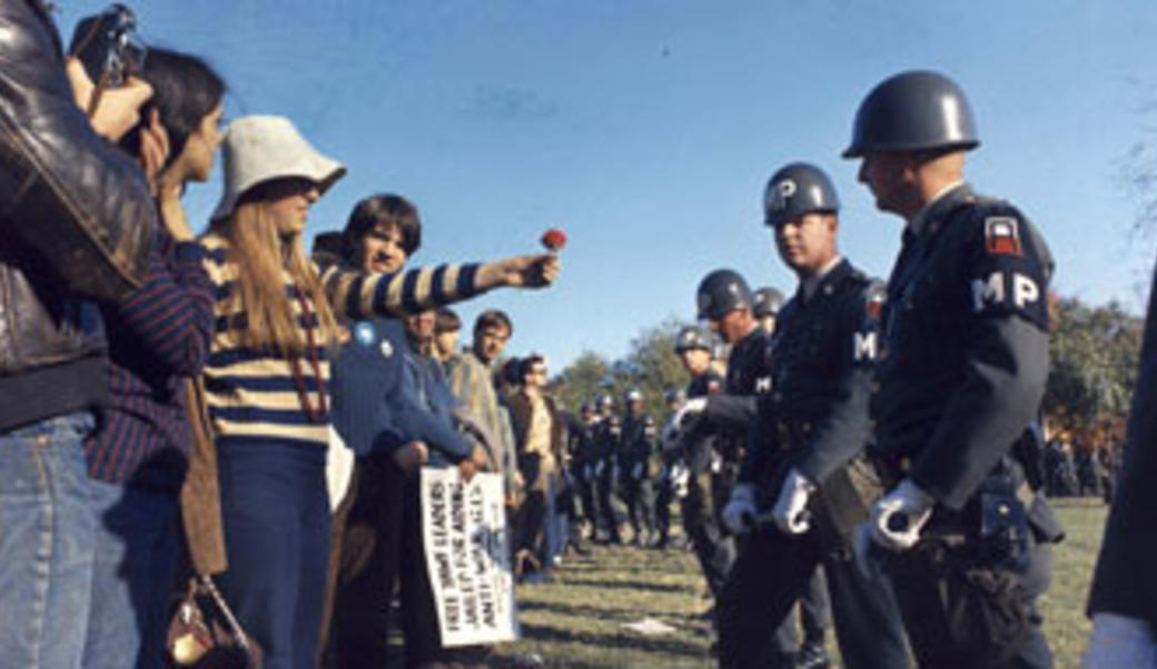 1960s hippie offering a flower to an MP