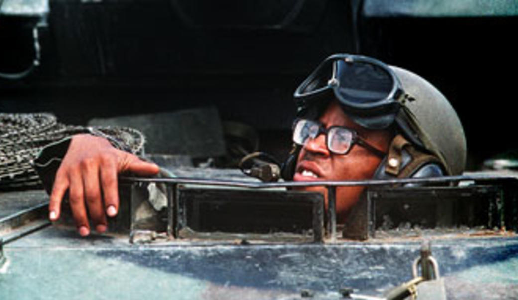 Marine looking out of hatch of armored personnel carrier