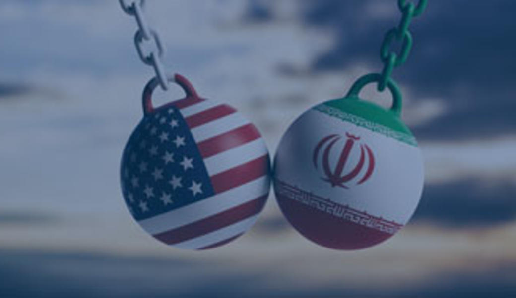 Wrecking balls with Iran and US flags painted on them colliding