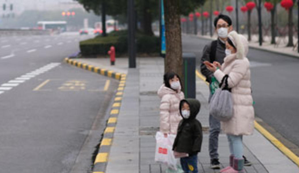 Chinese family on street wearing masks