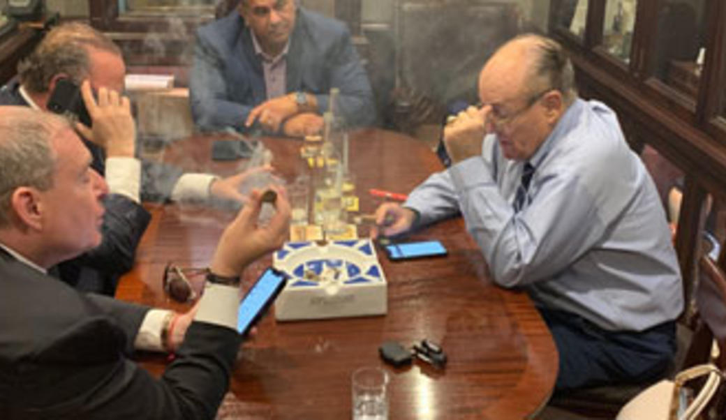 Rudy Giuliani and two other men smoke cigars