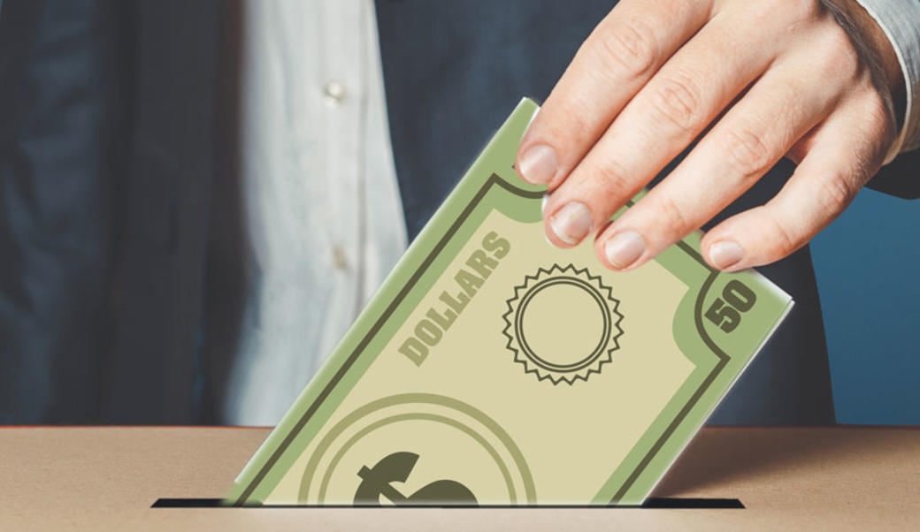 A voter dropping a dollar bill into the ballot box