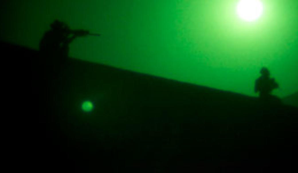 Soldier pointing weapon viewed through night goggles