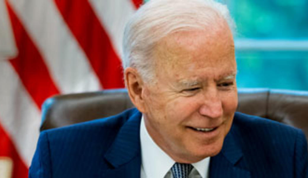 Joe Biden at desk with American flag in background