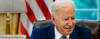 Joe Biden at desk with American flag in background